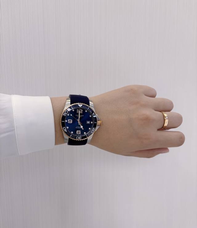 浪琴康卡斯，征服事业，征服爱情！ 深海蓝，是自由与沉稳的碰撞；那一缕金色光芒，是优雅与力量的交融。浪琴康卡斯潜水蓝盘金胶带，不只是腕表，更是心动的承诺。无论是犒