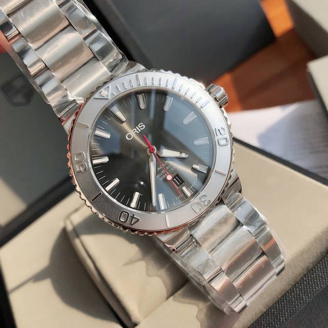 豪利时潜水系列新款来袭 腕表的灵感来自于水的颜色，灰色的表盘是波浪起伏的大海，银白色的时标像海中晶莹的水滴，红色的秒针十分抢眼，时标和指针都覆盖有Super-L