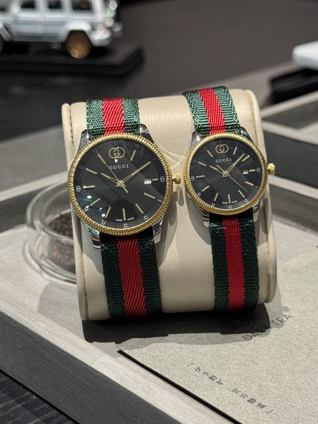 新款Gucci G-Timeless系列腕表匠心演绎品牌经典图案，不断为全新系列增色添彩。这款腕表配以绿色尼龙带和精钢表壳，银色表盘巧妙点缀标志性元素尺寸38M