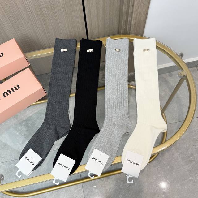 A box of four pairs of Miumiu socks with packaging. These super popular Miumiu s