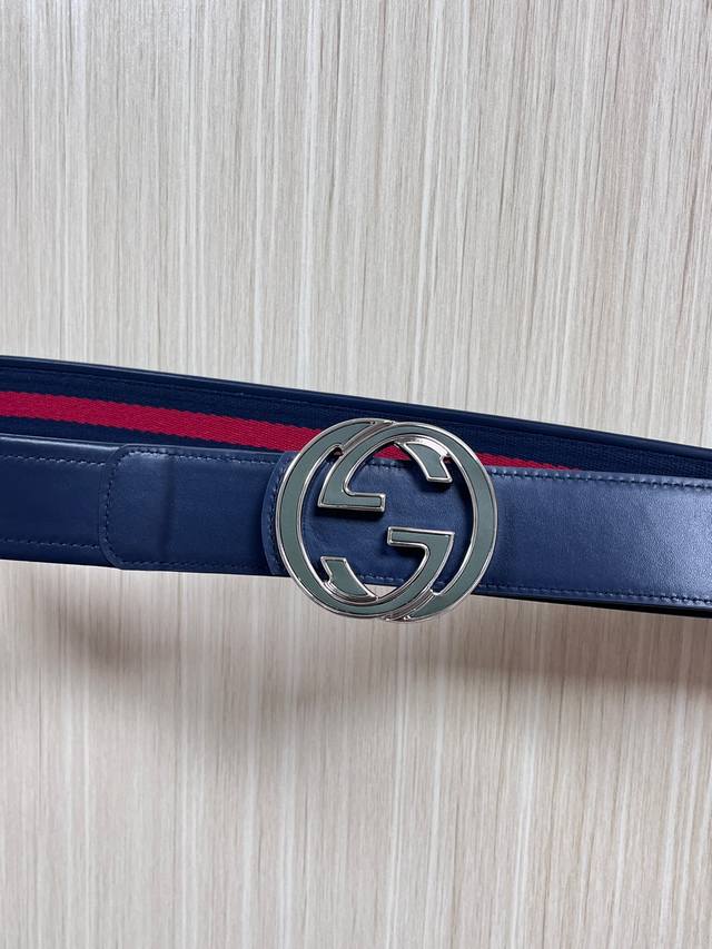 This reversible belt features red and blue webbing and blue cowhide leather, pai