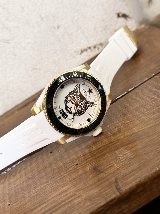 升级版原单品质 古驰 Gucci新款中性潜水表，40 Mm表径，以品牌标志性“猫”图案和夜光显示为表盘。应用不锈钢材质，经缎面拉丝润饰，并搭配与表盘配色一致的橡
