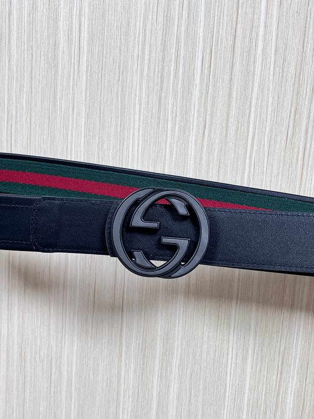 This reversible belt features red and green webbing and black cowhide leather,