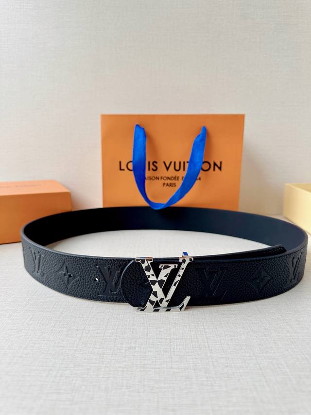 Classic Monogram embossing meets a rainbow buckle, exuding a sophisticated blac