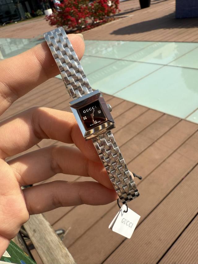 最新款古驰Gucci，G-Frame系列腕表采用优雅长方形表壳，巧妙融合典藏细节与现代时尚美学。这款腕表以精钢表壳匠心打造，巧妙搭配饰钻石粉色表盘，配罗马数字时