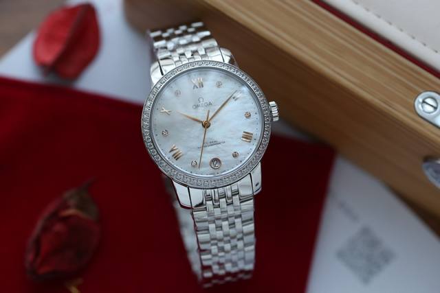 白 金 钢20 钻20 欧米+碟飞系列全自动机械机芯女表，直径34毫米，白色珍珠母贝表盘。指针经pvd处理，罗马数字刻度和弧面形小时刻度交替出现。表盘内饰以圆点