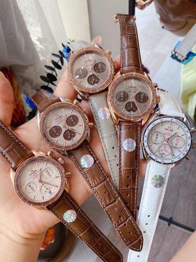 白壳 间枚 全枚金 麦芽糖MJ 欧米茄超霸系列38毫米腕表采用黄色18K金表壳搭配双表圈，镶嵌表圈内侧带有测速刻度的绿色铝质表圈。浅银色表盘上的黄色18K金小时